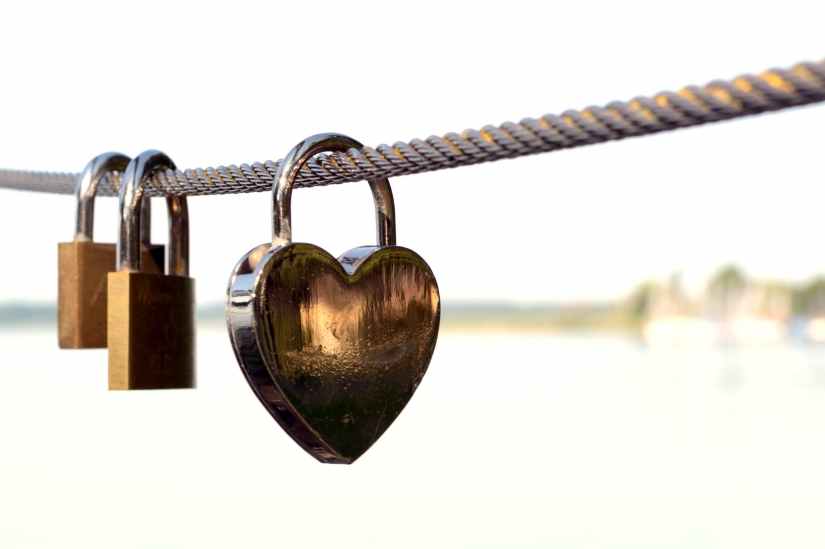 close up of padlocks on railing against sky
